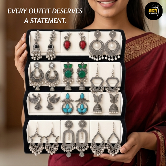 Woman holding a 12-pair oxidised silver-tone statement earrings collection with a velvet organiser box