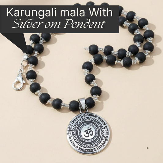 Black beaded necklace with silver Om pendant on a beige background

